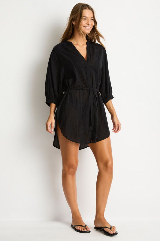 Woman wearing a black romper against a white background