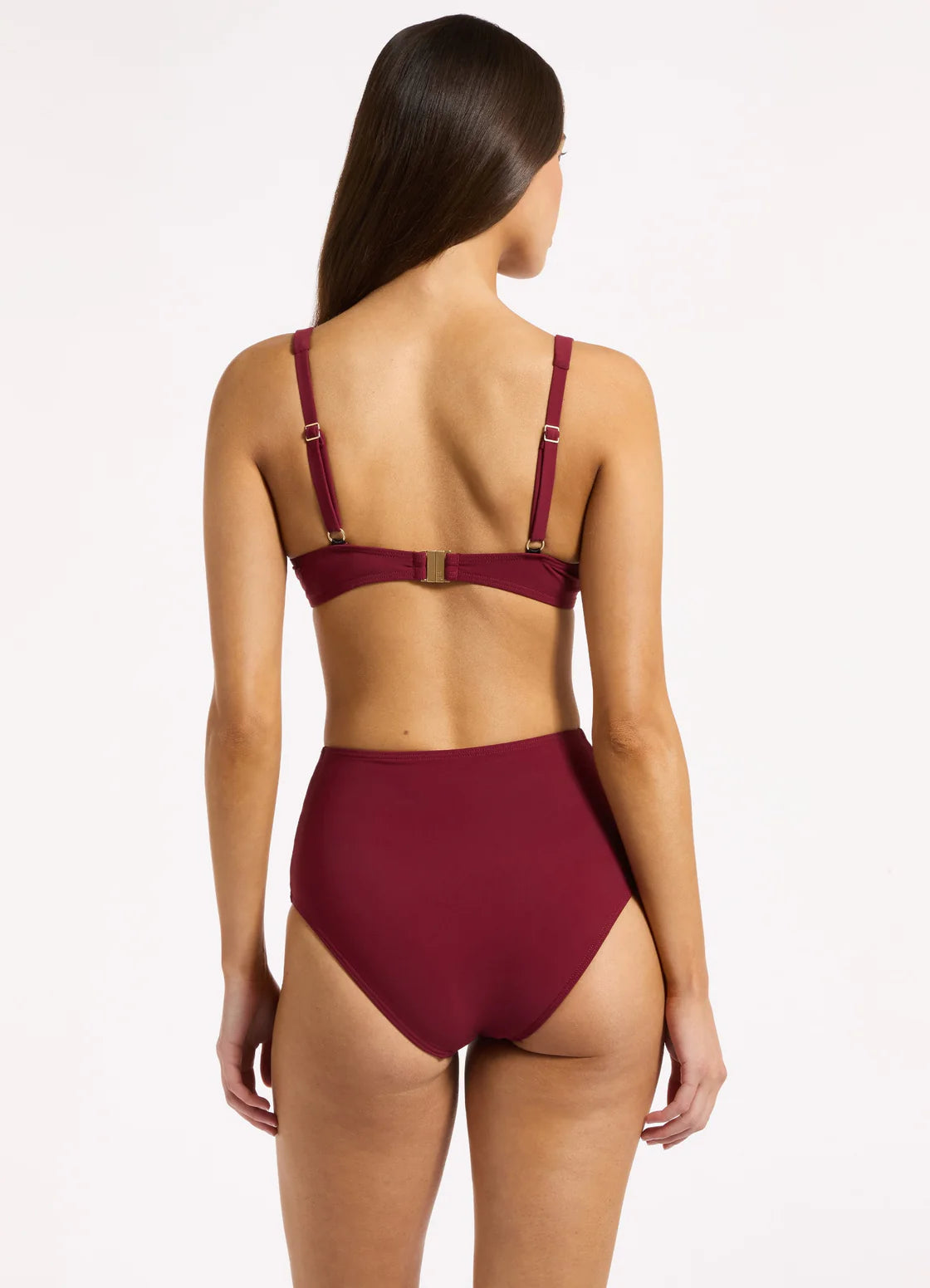 Woman wearing a burgundy swimsuit on a white background