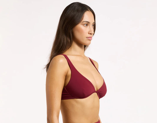 Woman wearing a burgundy bikini set on a white background