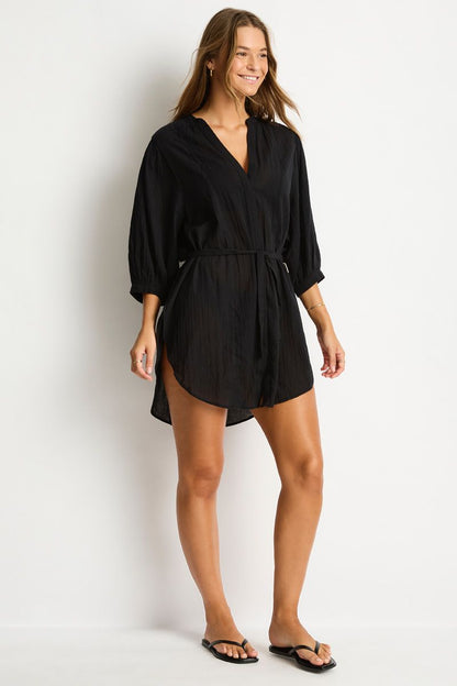 Woman wearing a black romper against a white background