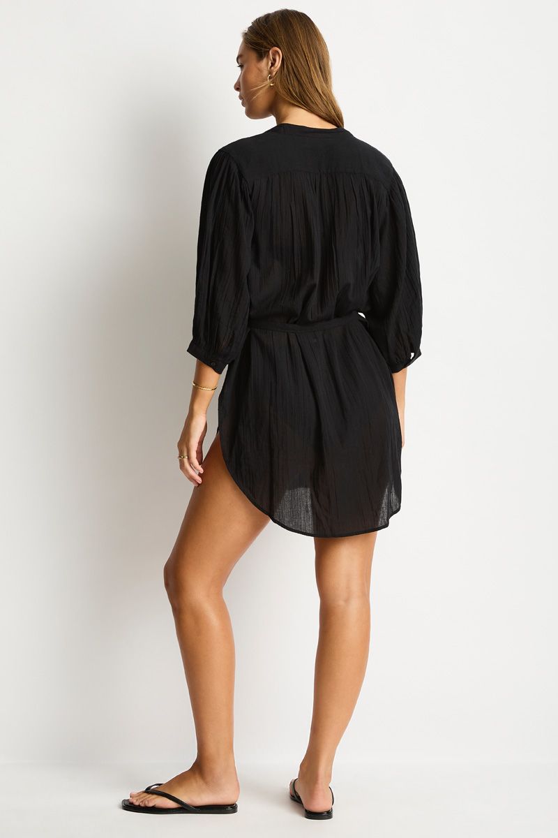 Woman wearing a black dress against a white background